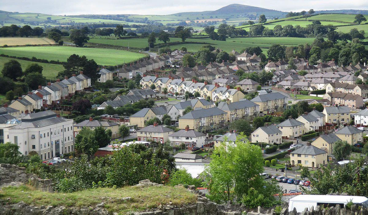 Llun o'r awyr o Dinbych Uchaf yn dangos y tai wedi'u hadnewyddu gyda rendr a thoeau newydd