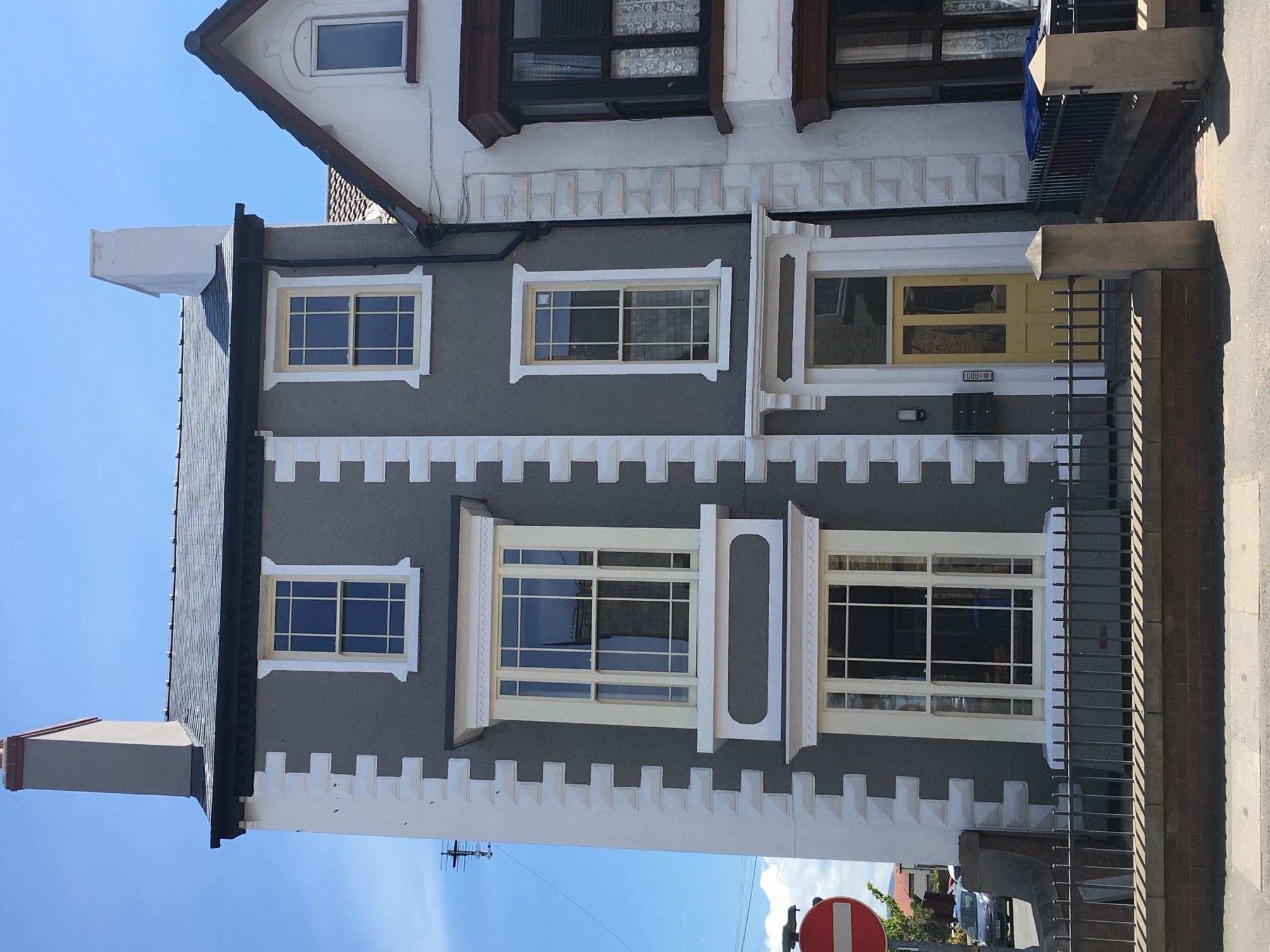 Semi-detached, 3 storey flats, with grey exterior and white brickwork around the edges of the windows