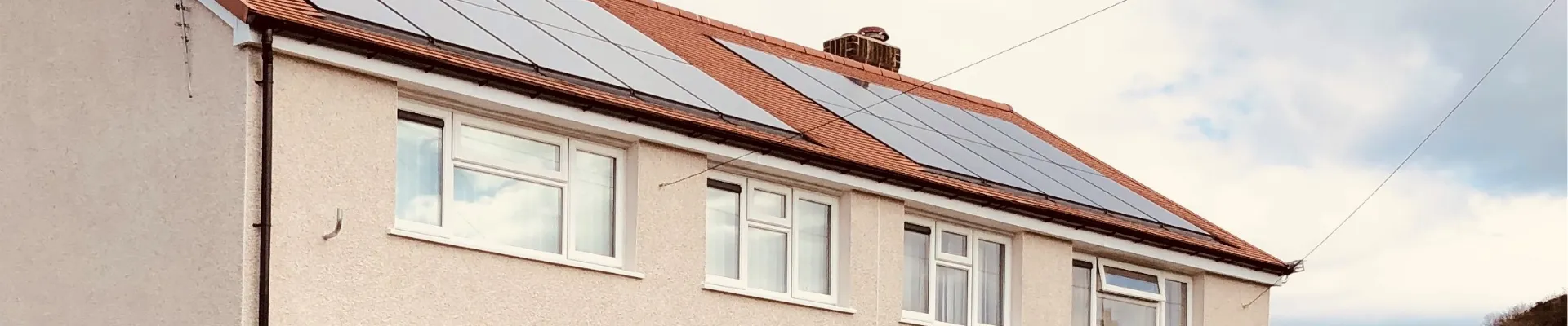 Eiddo dwyloïr wedi ei rendro yn frown gyda tho o daflenni coch a phaneli solar.