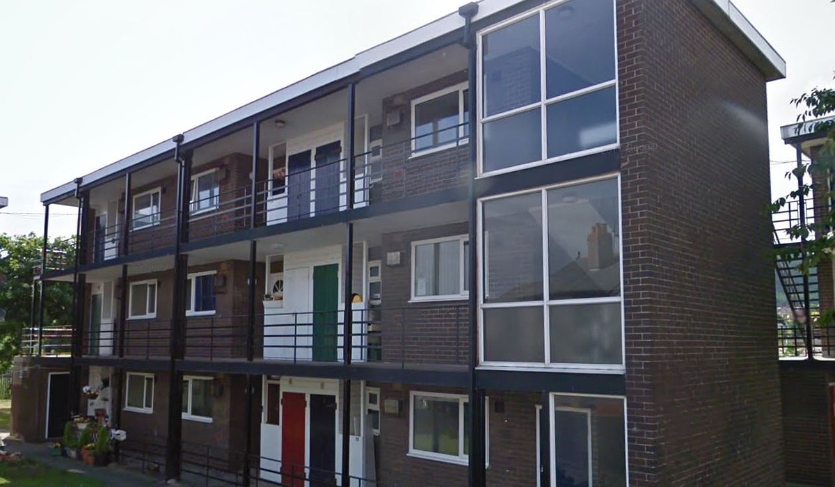 Hen fflatiau yn Heol Caradog, Prestatyn. Mae gan y fflatiau DU allan Brown gyda balconïau wedi'u cripo.