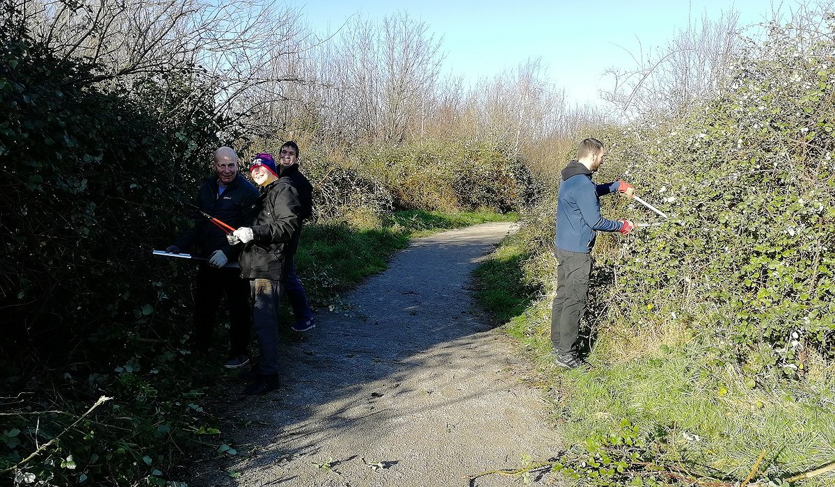 Tri dyn yn cymryd rhan mewn gwaith cadwraeth, tocio gwrychoedd yn y Rhyl fel rhan o'r prosiect natur ar gyfer iechyd.