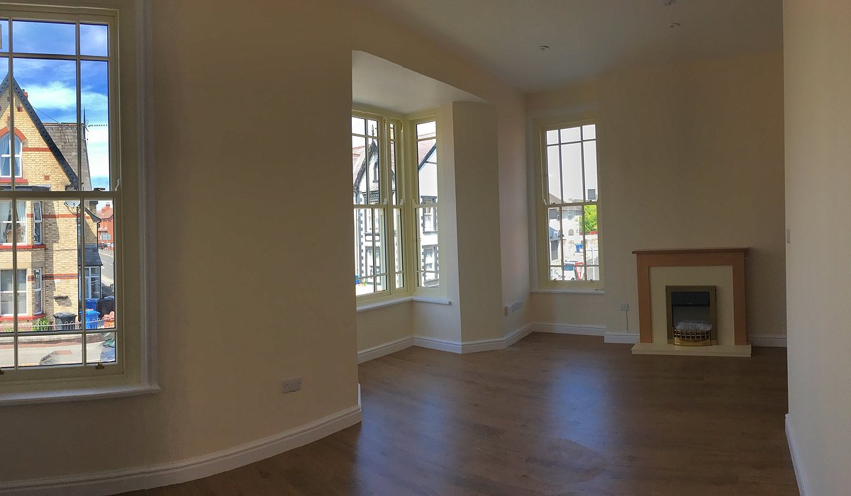 Ystafell liw hufen gyda lle tân a 3 Windows.