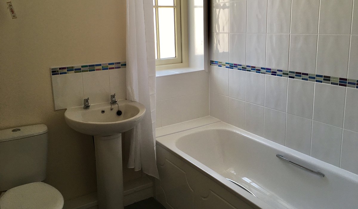 Ystafell ymolchi Wen newydd gyda dros y gawod bath.